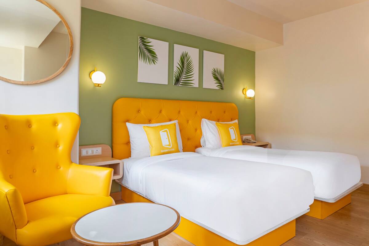 A hotel room with a large bed, two bedside tables, a chair, and a round table.