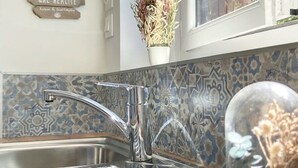Una cocina con un grifo moderno, un letrero decorativo y una ventana con vistas.