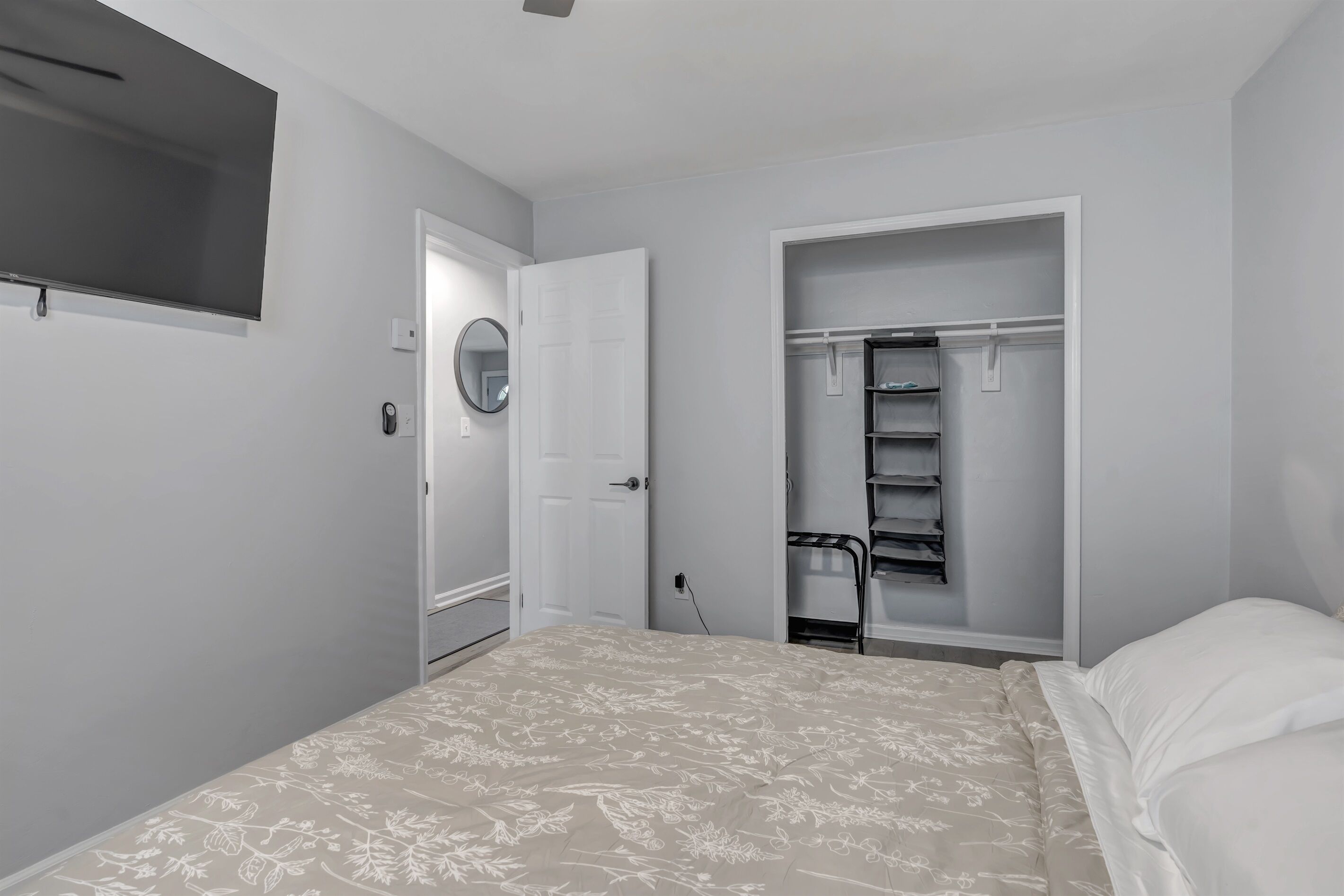 Un dormitorio con cama, armario y televisión integrada.