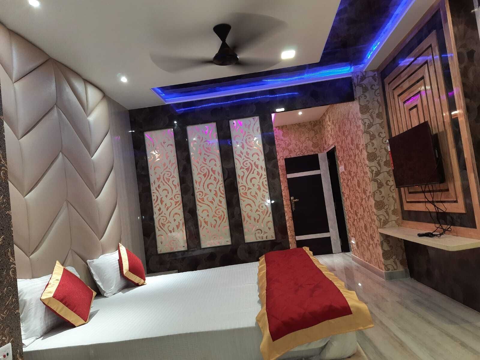 A modern bedroom with a bed, decorative panels, a ceiling fan, and a mounted TV.