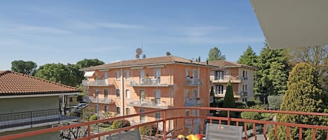 Ein Balkon mit Tisch, Stühlen und einer Obstschale.