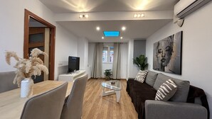 Una sala de estar moderna con un sofá, una mesa de centro y un televisor.