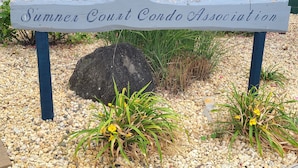 A wooden sign with the text "Summner Court Condo Association" surrounded by gravel, plants, and a rock. - Family Fun!! 2 Blocks to Famous Boardwalk & Beach. 3Br/2Fb. 4 Adults + Kids (Seaside Heights)