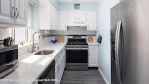 A modern kitchen with white cabinets, stainless steel appliances, and a blue accent wall. - Family Fun!! 2 Blocks to Famous Boardwalk & Beach. 3Br/2Fb. 4 Adults + Kids (Seaside Heights)
