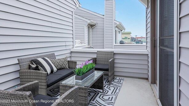 A balcony with wicker furniture, a glass table, and a potted plant. - Family Fun!! 2 Blocks to Famous Boardwalk & Beach. 3Br/2Fb. 4 Adults + Kids (Seaside Heights)