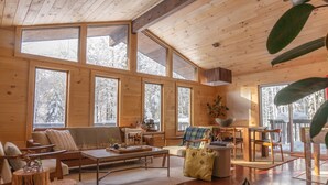 Eine geräumige Kabine mit großen Fenstern, Holzböden und einer gemütlichen Sitzecke mit Couchtisch.