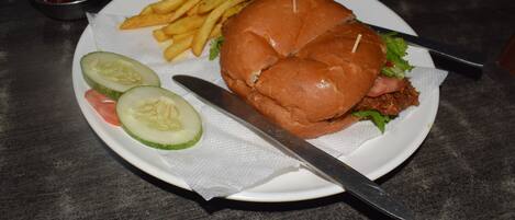 Un plato con un sándwich, papas fritas y rodajas de pepino.