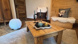 A cozy living room with a wooden coffee table, a fluffy white chair, and a sofa with a fur throw. - La Dorbluche duplex apartment 10-11 person, 2km from the slopes (Aime-la-Plagne)