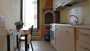 A kitchen with a tiled floor, a stove, a sink, and cabinets. - The Count's Vaults (Castro)