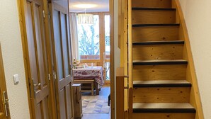 Eine Holztreppe führt zu einem Essbereich mit einem Tisch für zwei Personen.