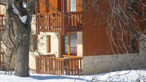 Ein Holzhaus mit Balkon, umgeben von Schnee.