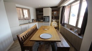A dining area with a wooden table, benches, and a white plate.