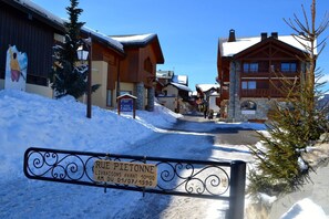 Calle nevada con edificios, incluyendo un cartel que indica Rue Pietonne.