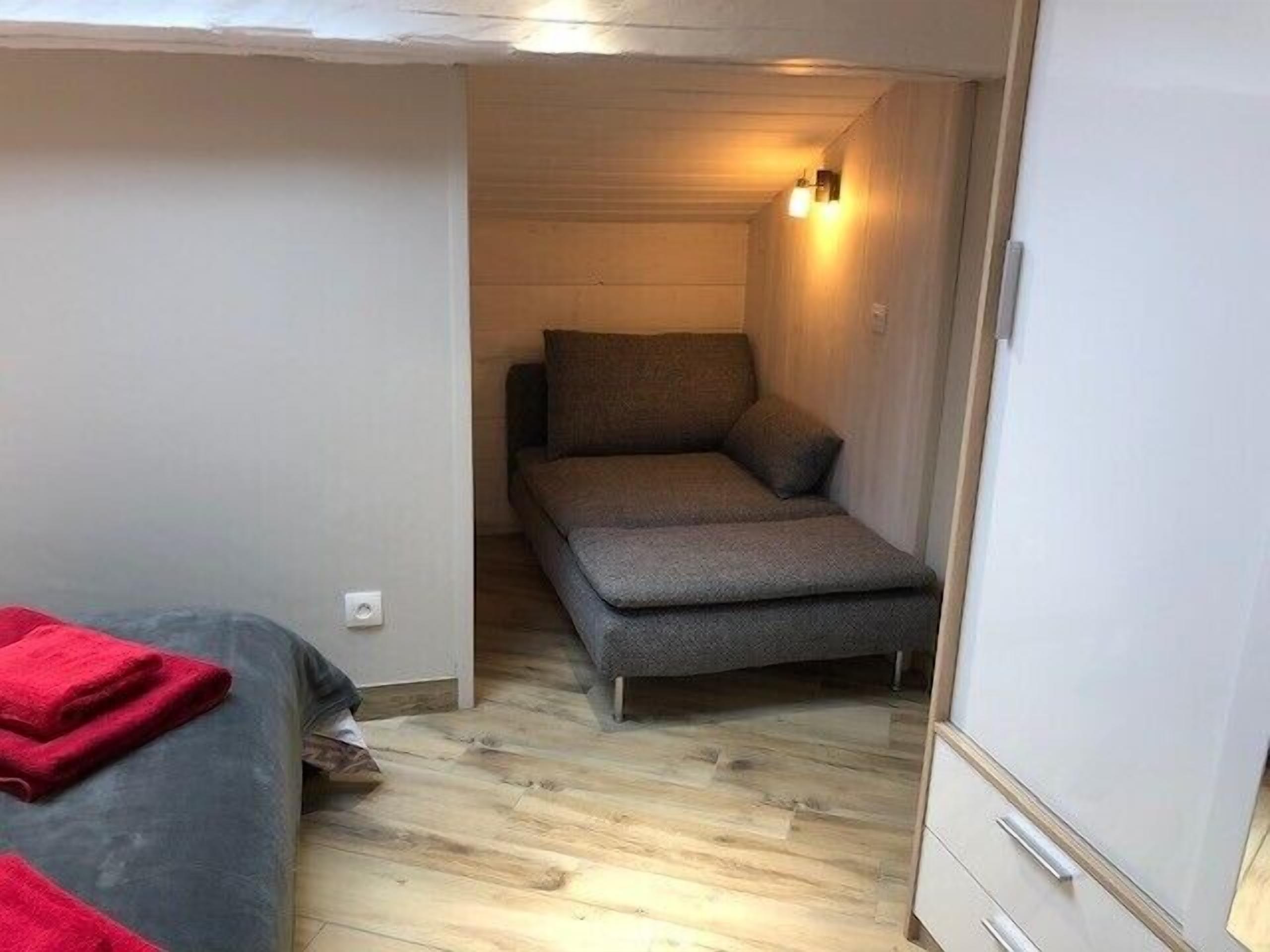 A compact room with a bed, a sofa, and a small table.