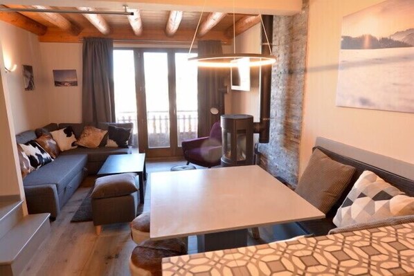 Una sala de estar acogedora con un sofá, una mesa de comedor y una chimenea.