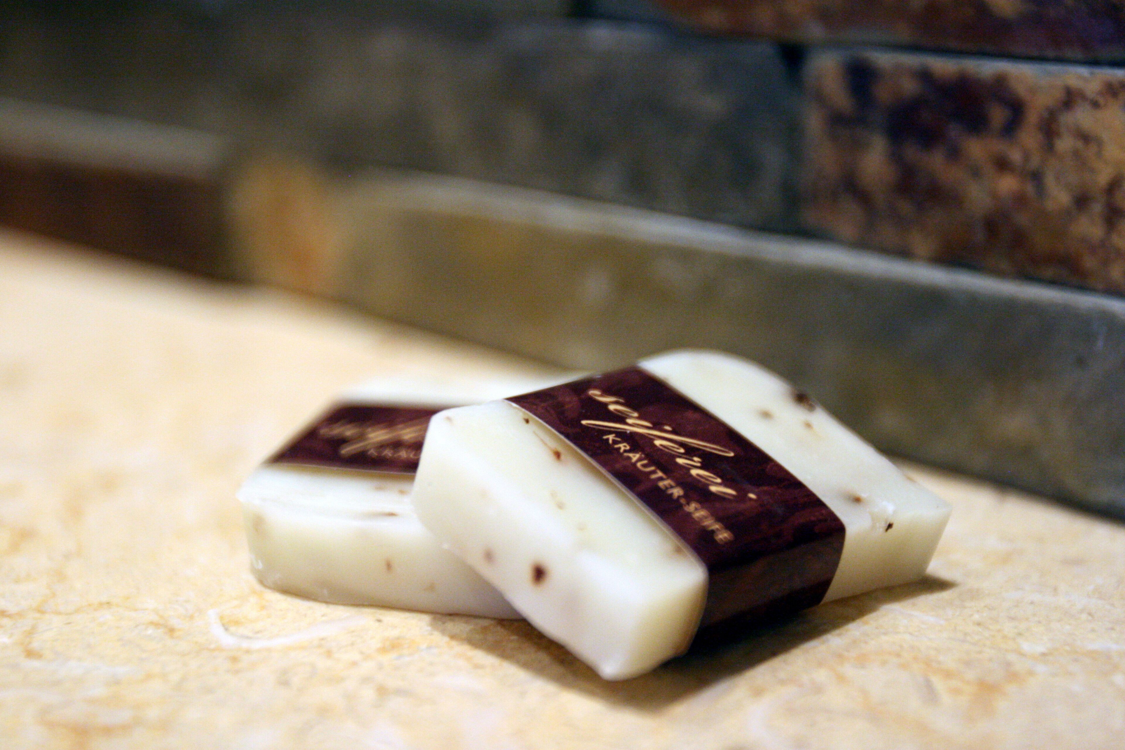 Tres trozos de chocolate blanco con envoltorio oscuro sobre una superficie rugosa.