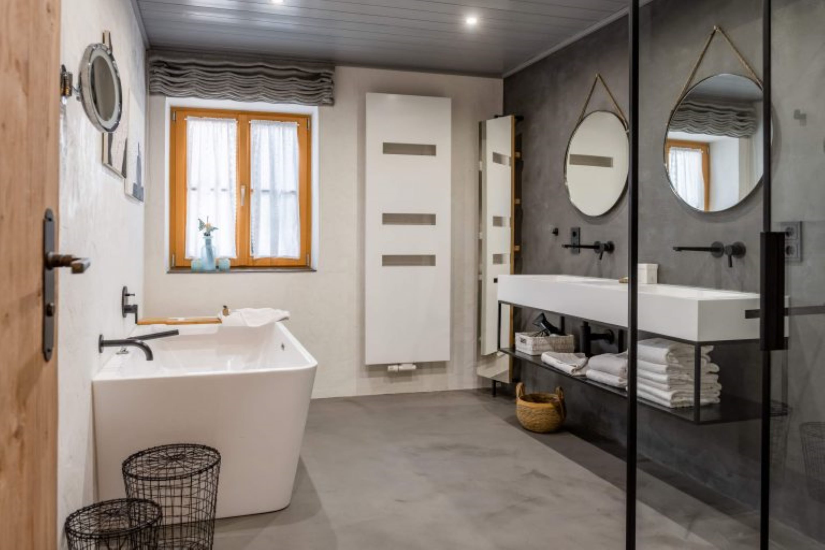 Une salle de bain moderne avec une baignoire sur pieds, une douche à parois de verre et un meuble-lavabo avec un miroir.