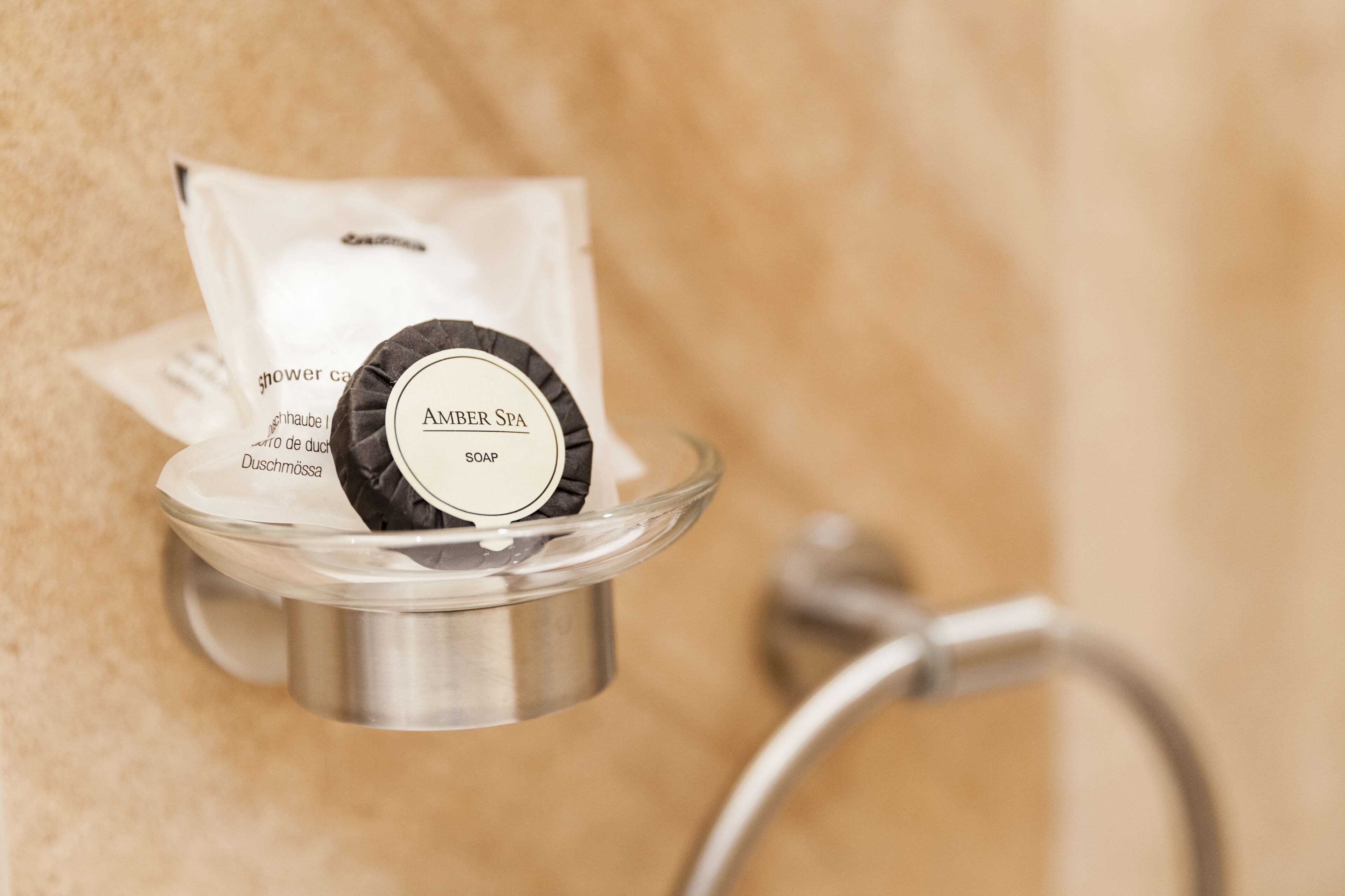 Un distributeur de savon avec une étiquette indiquant « SAVON AMBRE », placé dans une salle de bain.