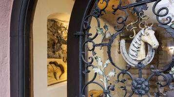 A wrought iron gate with a horse emblem, part of a building's entrance.