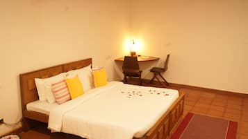 A bedroom with a wooden bed, a desk, and a chair.