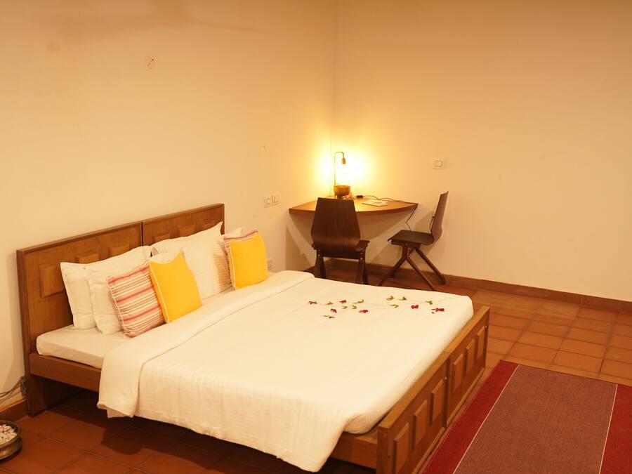 A bedroom with a wooden bed, a desk, and a chair.