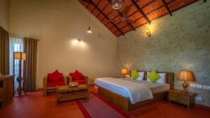 Un dormitorio con una cama, dos mesitas de noche, un banco de madera y una alfombra roja.