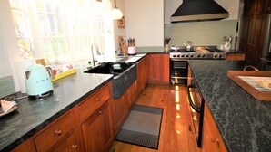 A kitchen with wooden cabinets, a black countertop, and a large window.