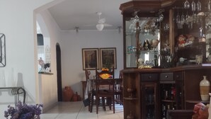 Un salon comprenant un coin repas, une cheminée et une collection de verrerie.