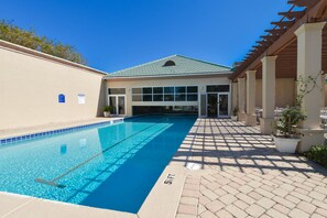 A swimming pool with clear blue water, a covered patio area, and a building with large windows and a green roof. - Incredible Gulf Views from the 3rd Floor at Silver Shells St. Croix! (Destin)