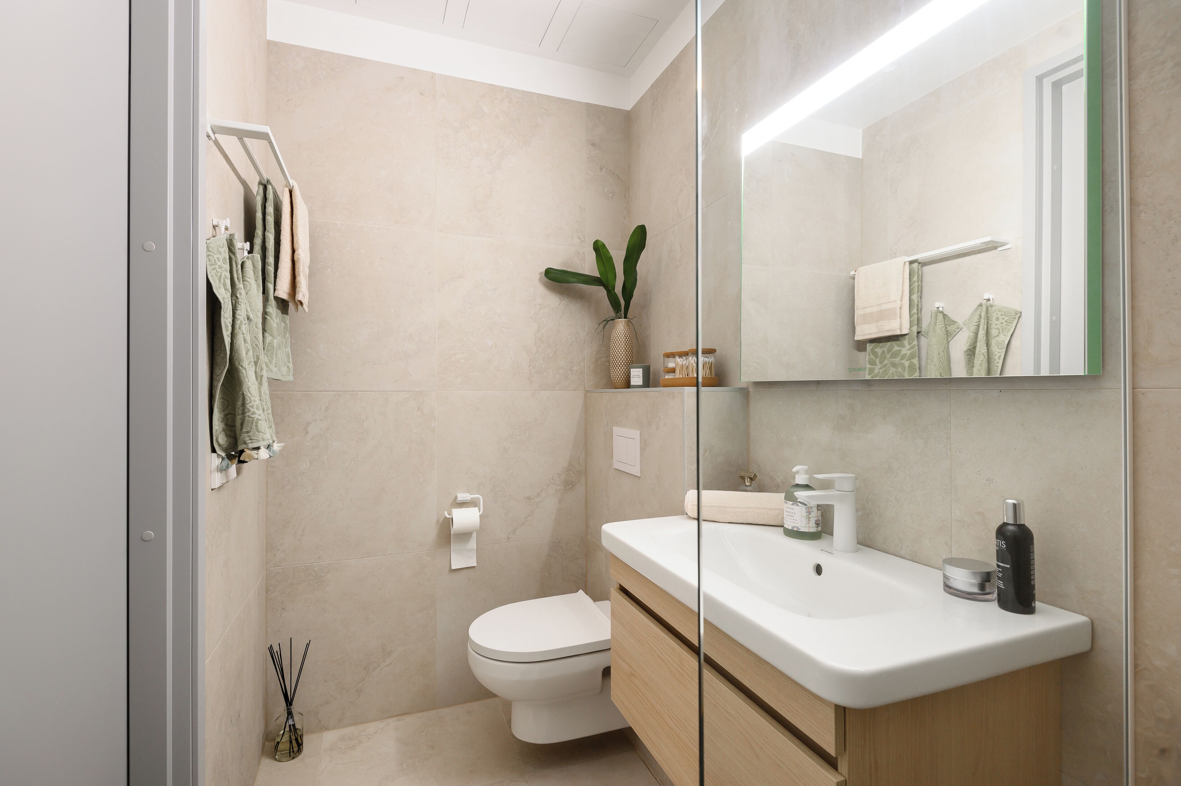 A modern bathroom with a toilet, sink, and mirror.