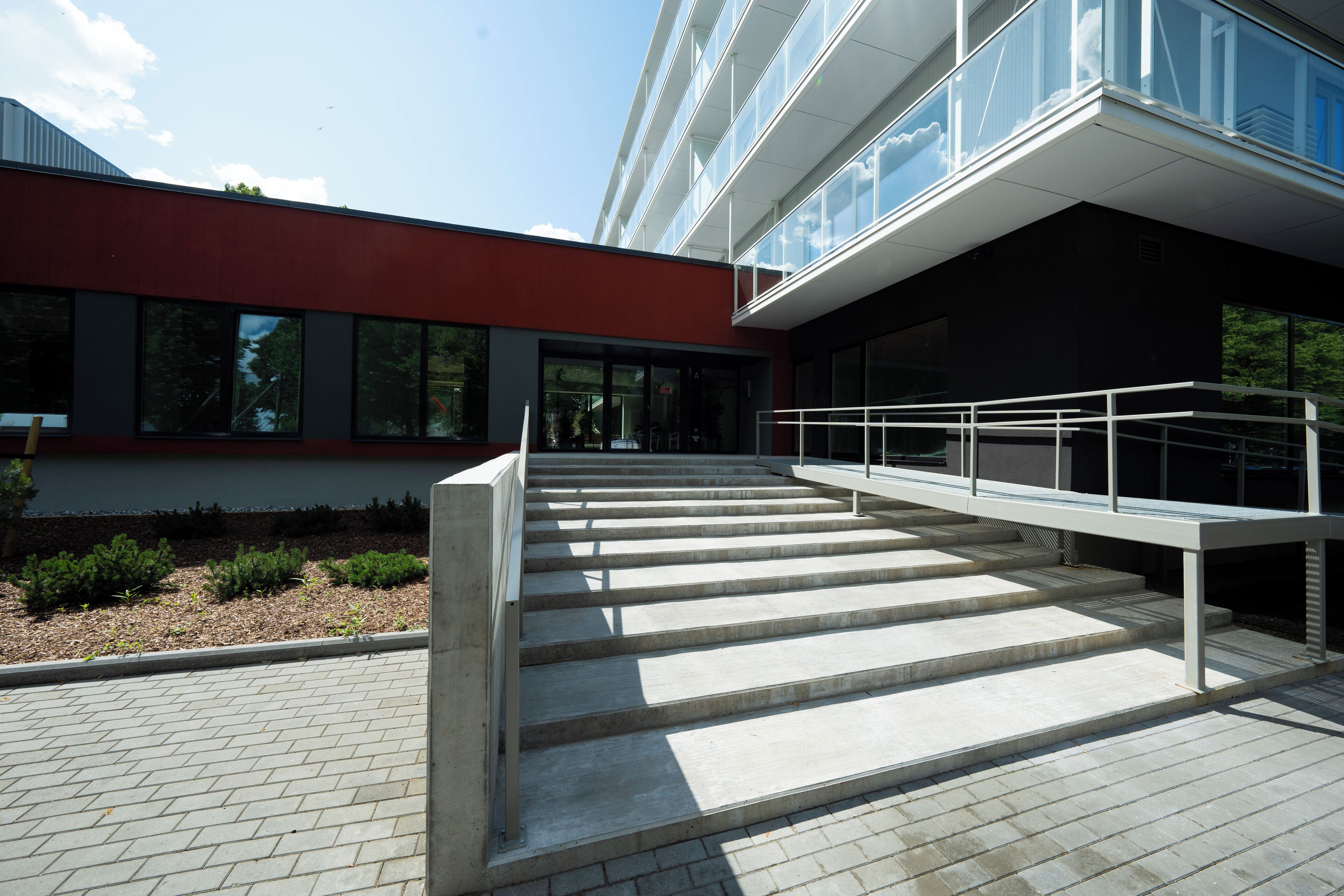 A modern building with a red facade and large windows.