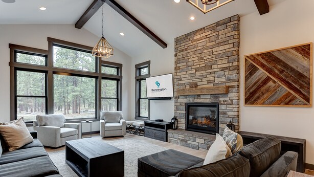 A modern living room with a stone fireplace, large windows, and a comfortable seating area. - SABL14 - Stunning Caldera Springs, Gourmet Kitchen, Heated Patio, New Hot Tub (Sunriver)