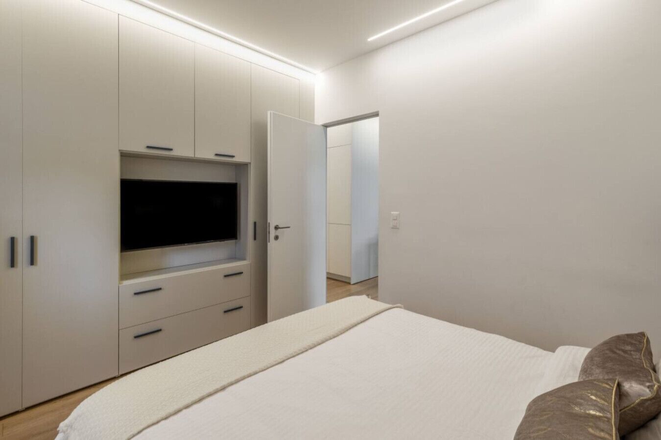 Een slaapkamer met een bed, een televisie en een kledingkast.
