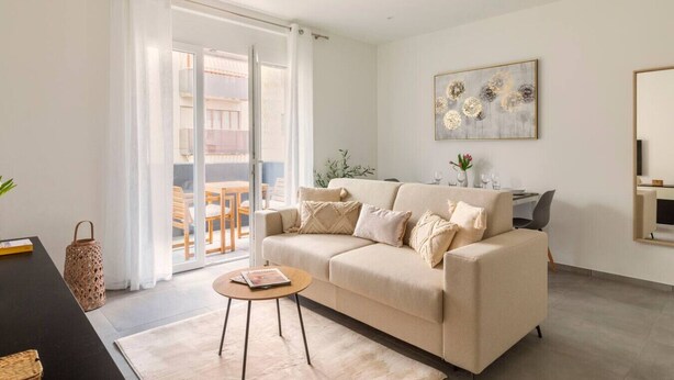 Un salon moderne comprenant un canapé, une table basse et un coin repas avec des chaises et une table.