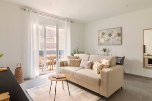A modern living room with a sofa, coffee table, and a dining area with chairs and a table. - Exclusive apartment with parking and air conditioning (Lugano)