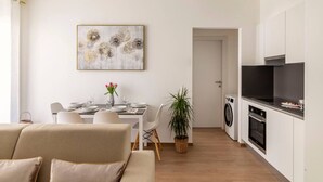 Un appartement moderne comprenant un coin repas, un salon et une cuisine.