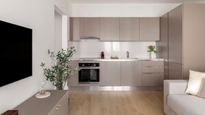 Una cucina moderna con elettrodomestici in acciaio inossidabile, forno integrato e un'ampia finestra.