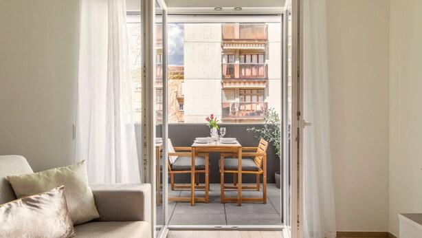Un appartamento moderno con balcone, angolo ristoro e divano.