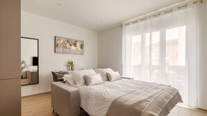 Una camera da letto moderna con un letto grande, un comodino, uno specchio e un quadro appeso al muro.