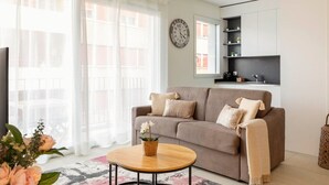 A living room with a sofa, a coffee table, and a clock on the wall.
