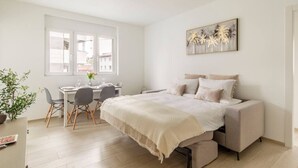 Une chambre à coucher moderne avec un lit, des tables de chevet, un bureau et une chaise.