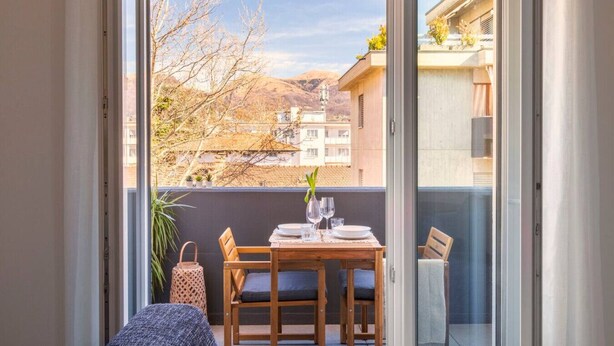 Ein Balkon mit einem Tisch für zwei Personen, einem Stuhl und einer kleinen Pflanze.