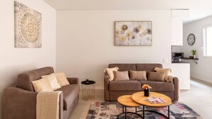 Ein modernes Wohnzimmer mit zwei Sofas, einem Couchtisch und Kunstwerken an den Wänden.