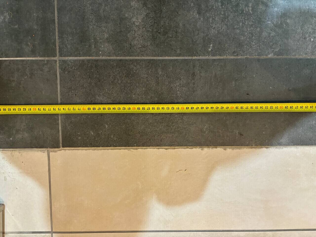 Una sección de suelo con baldosas y un metro.