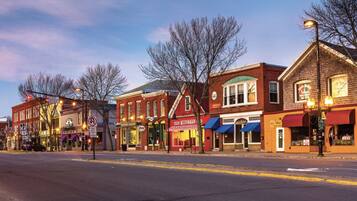 A street lined with historic buildings, some with storefronts and signage, under a twilight sky.