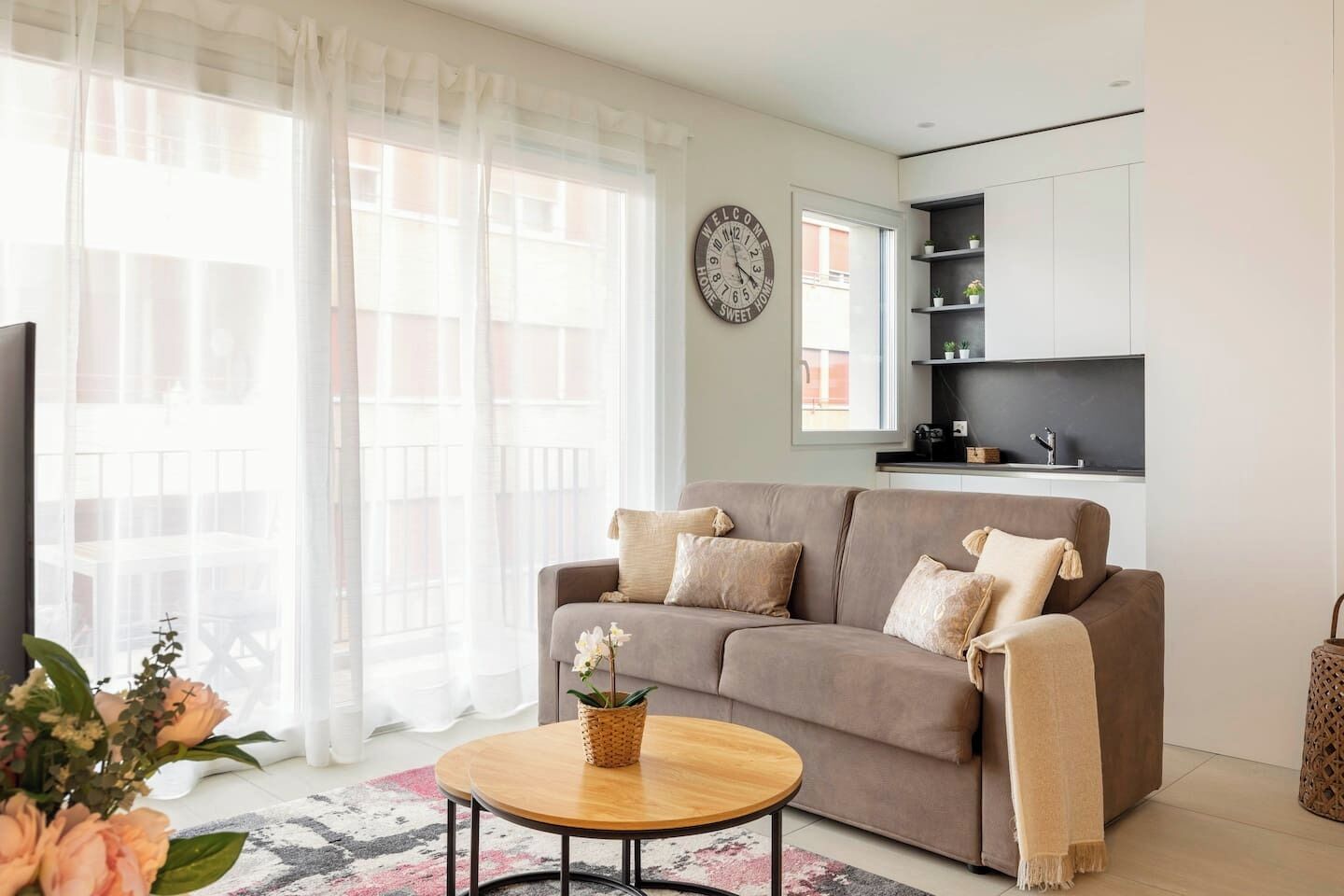 A living room with a sofa, a coffee table, and a clock on the wall.