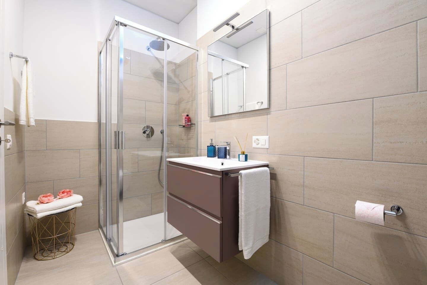 Une salle de bain moderne avec une douche à parois de verre, un meuble-lavabo avec un miroir et des toilettes.