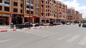 A multi-story building with various commercial establishments on the ground floor, including a hair salon and a coworking space. - Amoud apartments & flats (Marrakech)