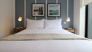 A neatly made bed with white linens, two framed pictures on the wall, and bedside lamps. - w* | Fantastic 2BR with Balcony in Miraflores (Miraflores)