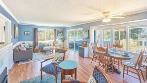 A spacious living room with a large dining table, comfortable seating, and a view of the outdoors. - Dogs Ok, Large Deck, BBQ, Fire pit, Close to Beach (Brock) (Long Beach)